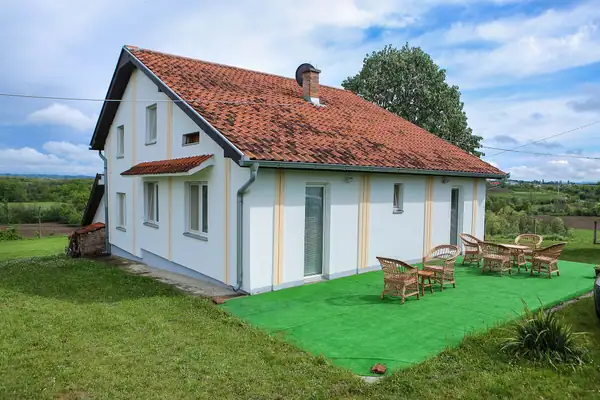 Villa Teo-Sport with a red tile roof and a landscaped green yard