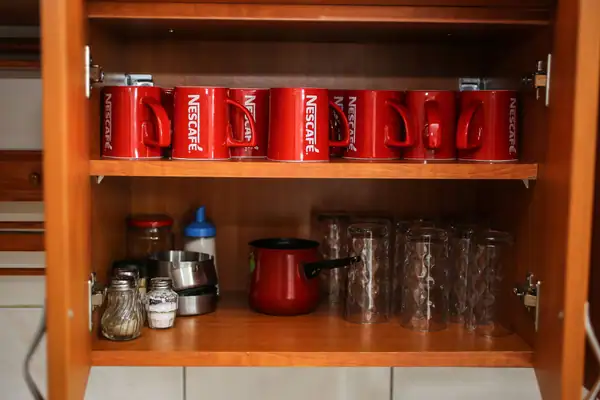Mugs and tableware in a kitchen cupboard