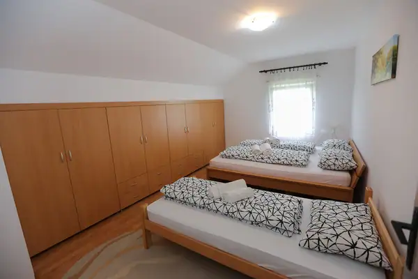 Room with a wardrobe and two beds
