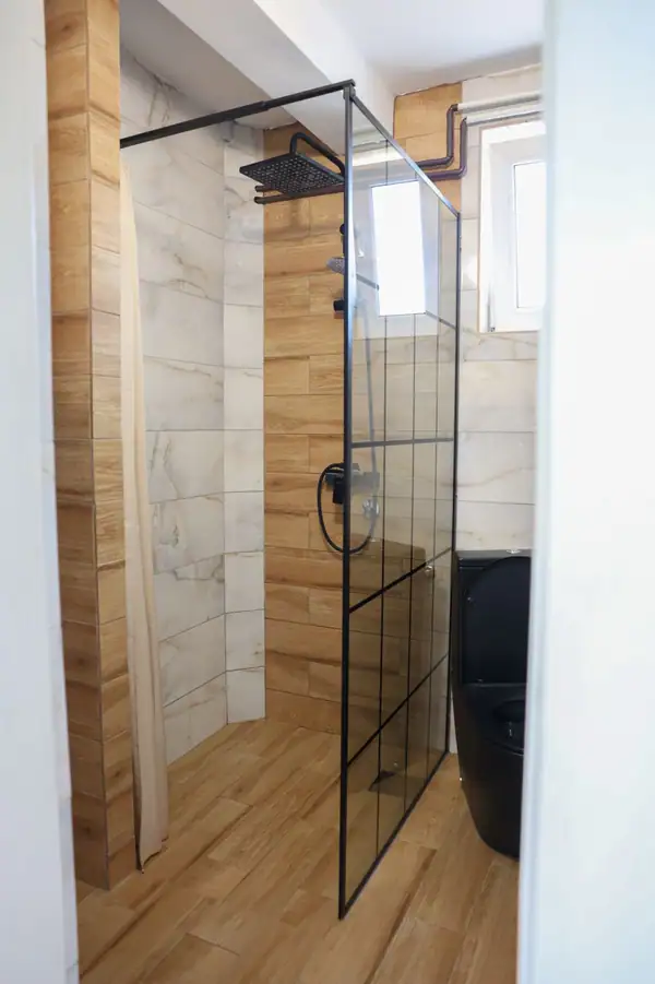 Shower with a glass wall and wood-effect tiles