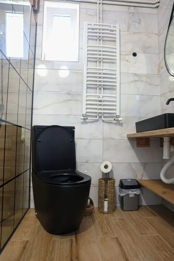 Modern bathroom with a black toilet and shower