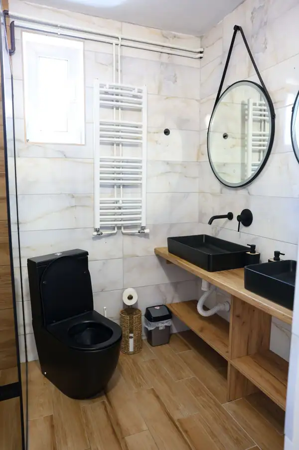Bathroom with a black basin and round mirror