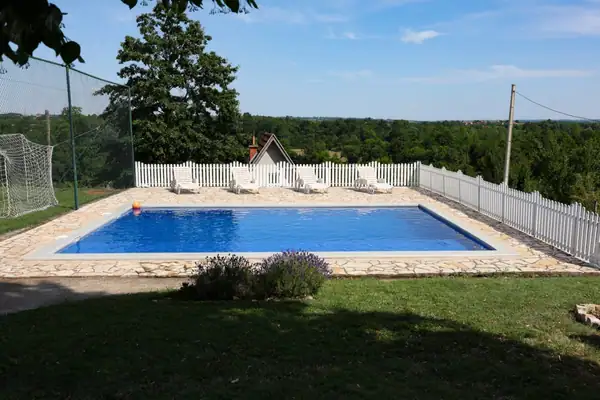Swimming pool with sun loungers and a view over the greenery